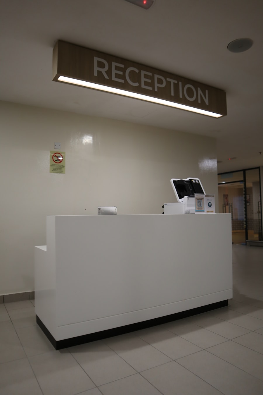 Reception desk beneath a lit Reception sign in a medical office