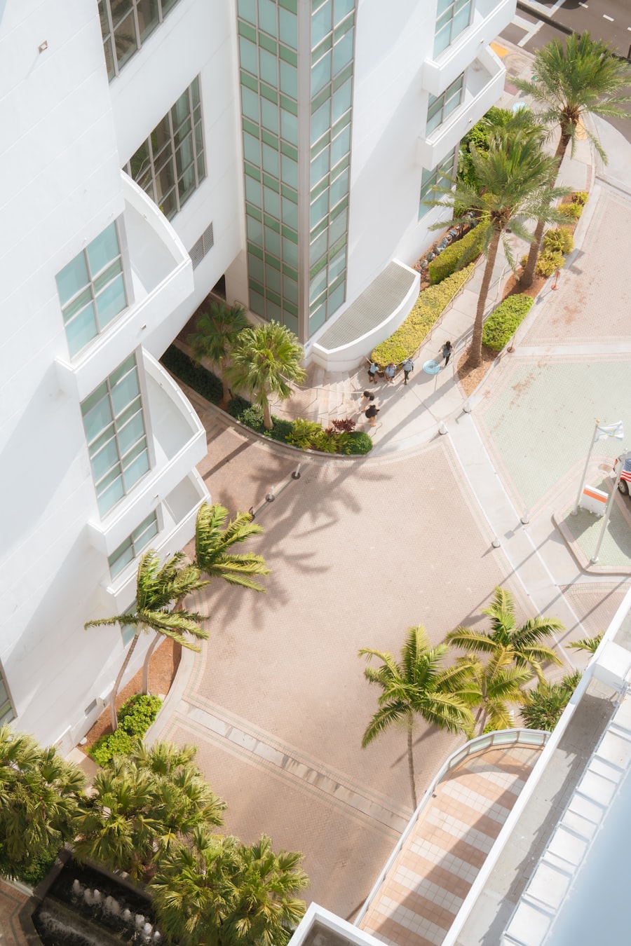 Aerial view of a white apartment building courtyard with palm trees